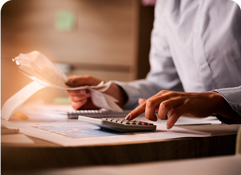 Person calculating expenses with receipts and calculator.
